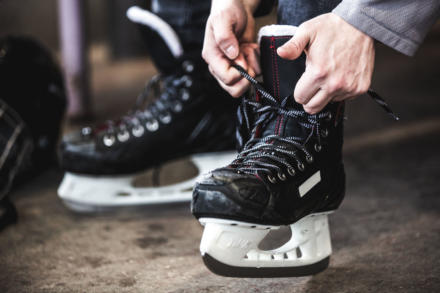 Image of a person lacing their hockey skates while wearing our socks